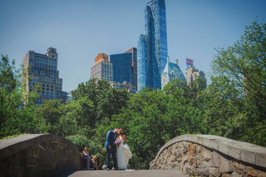 Kiss on Gapstow Bridge with the Manhattan skyline - Central Park Wedding - New York City